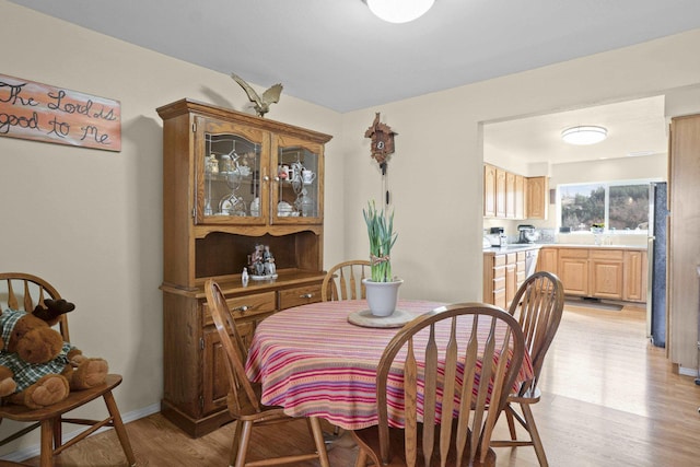 dining room with light wood-style flooring and baseboards