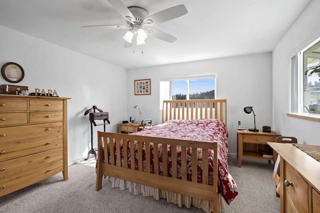 bedroom with a ceiling fan and light colored carpet