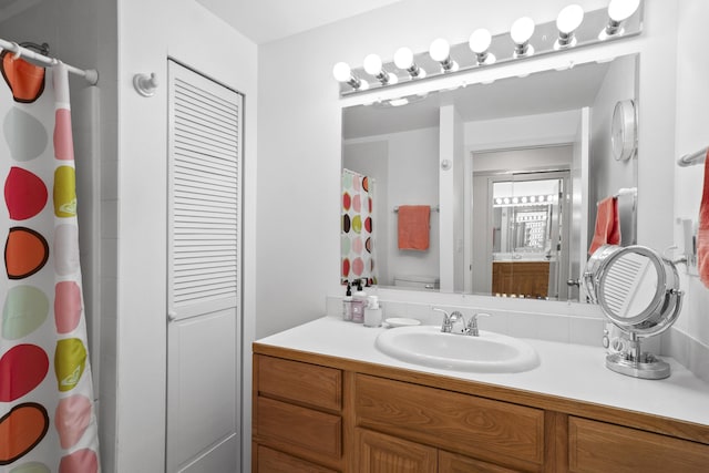 bathroom with toilet, a shower with shower curtain, and vanity