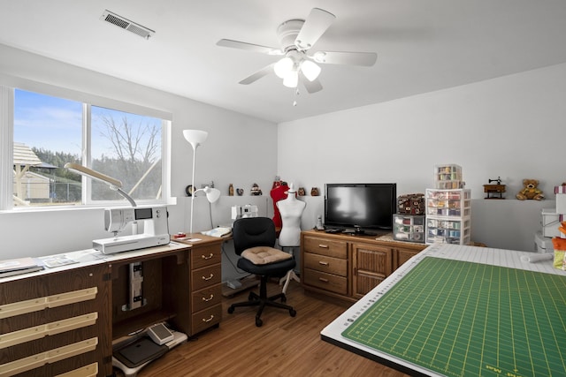 bedroom featuring a ceiling fan, visible vents, and wood finished floors