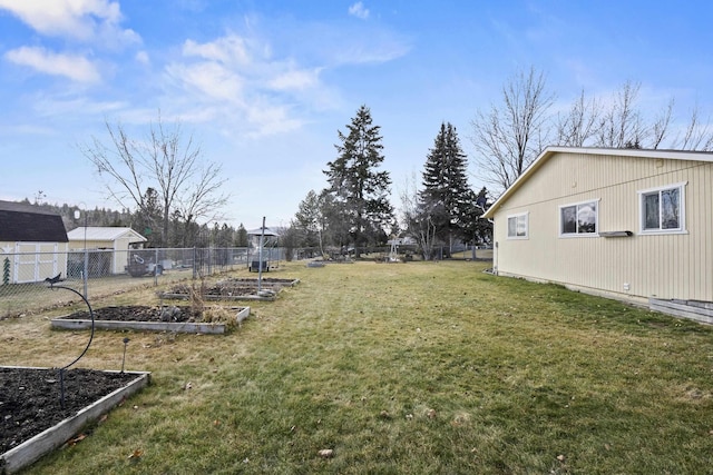 view of yard with a vegetable garden and fence