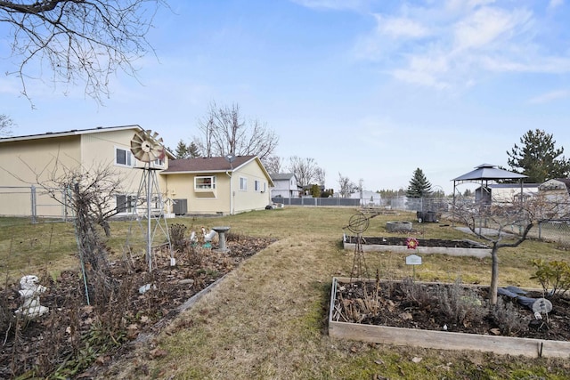 view of yard with central AC unit, a garden, and fence