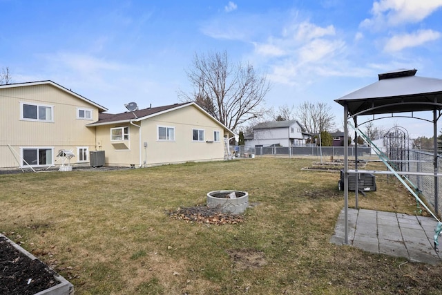 view of yard with central AC, fence, and a gazebo