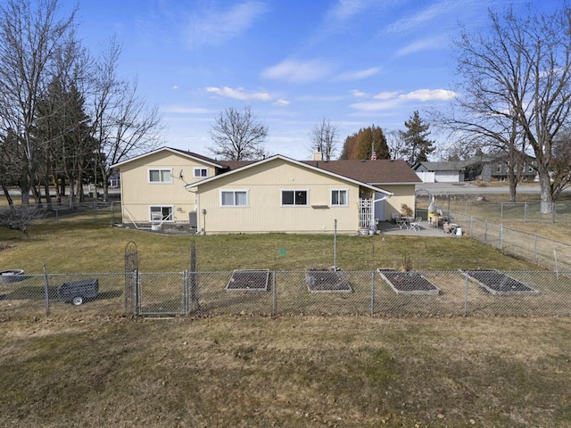 rear view of house featuring a patio, a lawn, and a fenced backyard