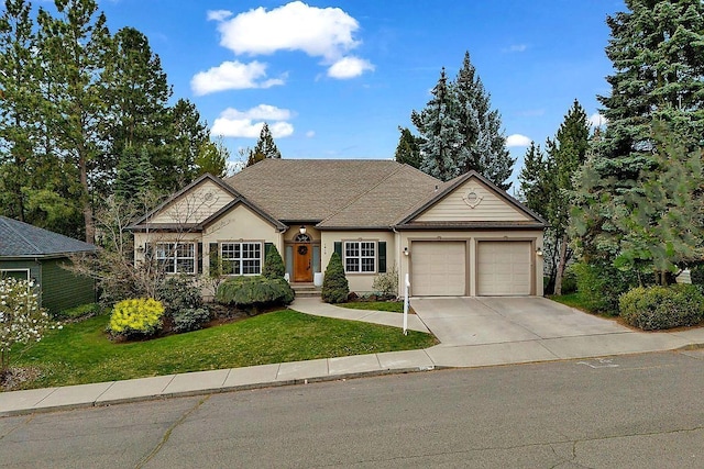 view of front of property with an attached garage, a front yard, concrete driveway, and stucco siding