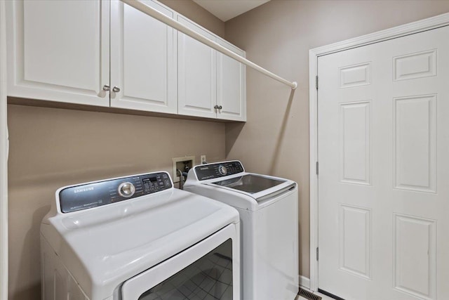 laundry area featuring washer and clothes dryer and cabinet space