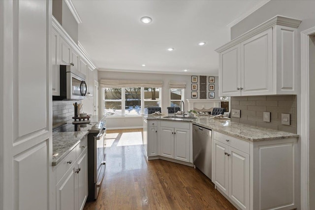 kitchen featuring stainless steel appliances, white cabinetry, and a sink