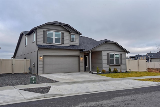 view of front facade featuring a gate, driveway, an attached garage, and fence