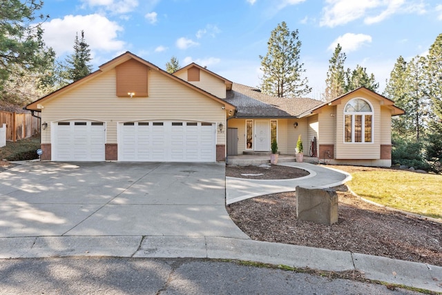 view of front of house with driveway, a garage, and roof with shingles