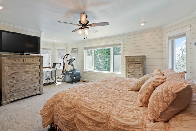 carpeted bedroom with ornamental molding, a wall mounted air conditioner, and a ceiling fan