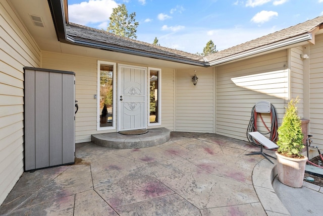 property entrance with a patio and visible vents