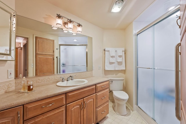 bathroom with toilet, a stall shower, and vanity