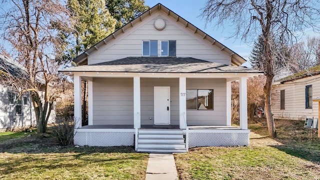 bungalow-style home featuring a porch, a front yard, and roof with shingles