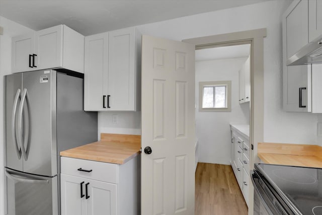 kitchen with stainless steel appliances, light wood finished floors, wooden counters, and white cabinets