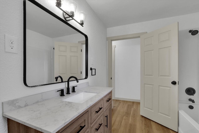 full bathroom featuring a bathtub, wood finished floors, and vanity