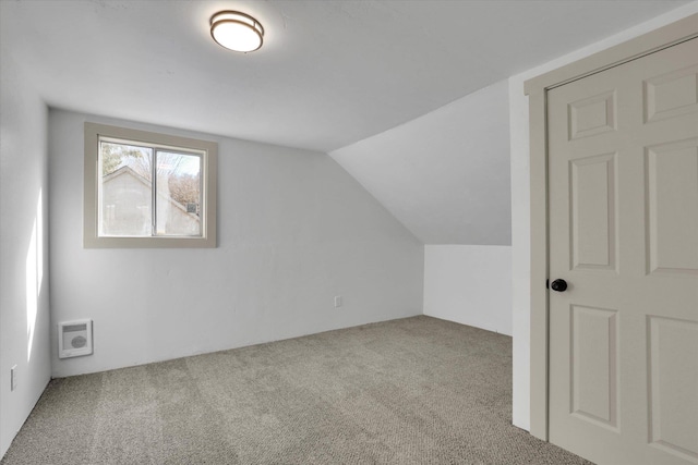 additional living space with carpet flooring, vaulted ceiling, and visible vents