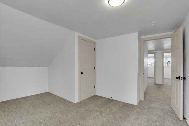 bonus room featuring lofted ceiling and carpet floors