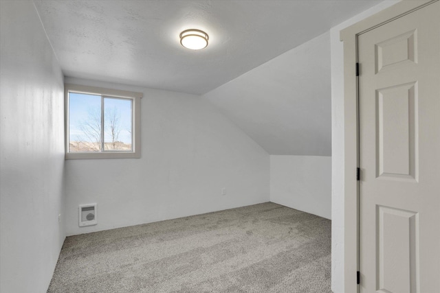 additional living space with lofted ceiling, carpet, and visible vents