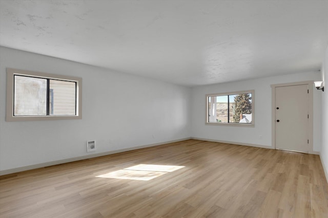 spare room with light wood-style floors and baseboards