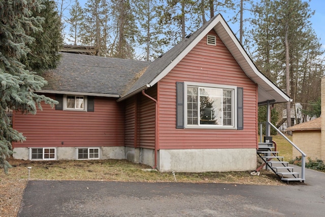 view of property exterior with a shingled roof