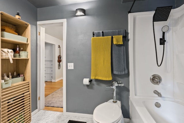 bathroom featuring shower / bathtub combination, toilet, and baseboards