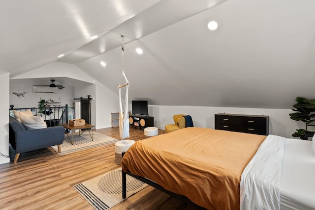 bedroom with recessed lighting, light wood-style flooring, vaulted ceiling, and a wall mounted air conditioner