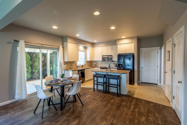 dining space with baseboards, wood finished floors, and recessed lighting