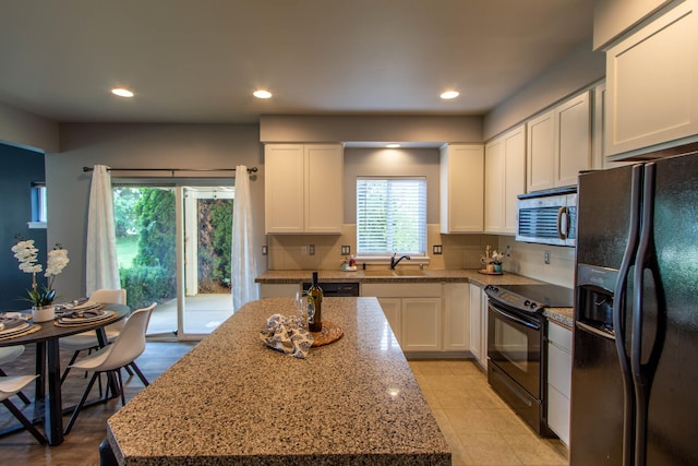 kitchen featuring recessed lighting, white cabinetry, a sink, and black appliances