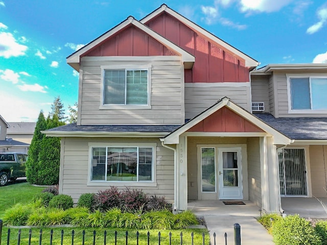 view of front facade with a front lawn, board and batten siding, and roof with shingles