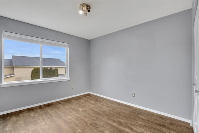 empty room featuring baseboards and wood finished floors