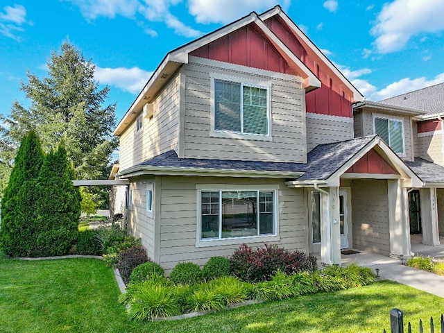 view of front of property featuring roof with shingles, board and batten siding, and a front yard