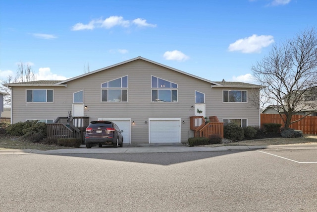 raised ranch with a garage and fence