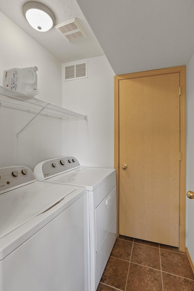 laundry area featuring visible vents, a textured ceiling, separate washer and dryer, laundry area, and dark tile patterned floors