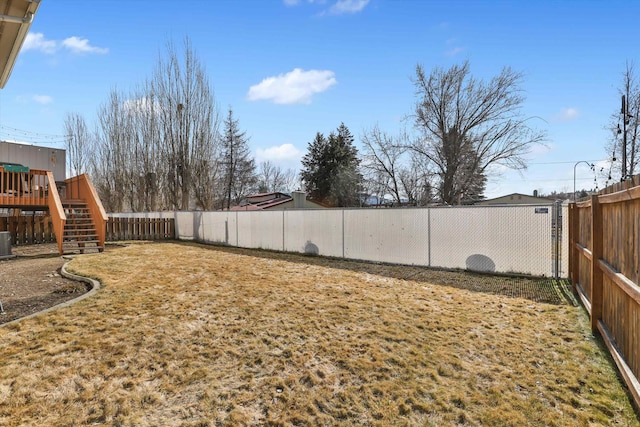 view of yard with a fenced backyard and central AC unit