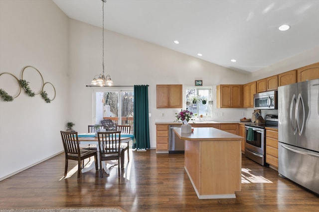 kitchen with a kitchen island, dark wood-type flooring, decorative light fixtures, stainless steel appliances, and light countertops