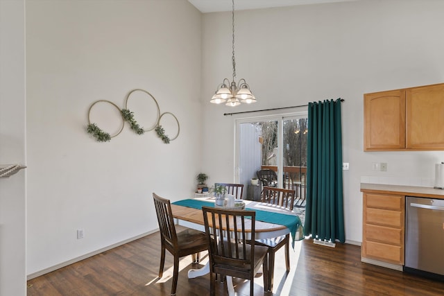 dining space featuring baseboards, dark wood finished floors, a high ceiling, and an inviting chandelier