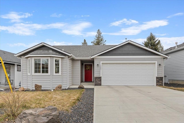 ranch-style home featuring driveway, stone siding, roof with shingles, and an attached garage