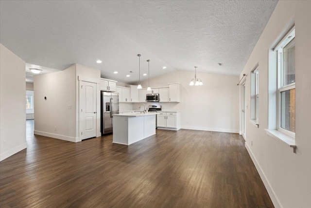 kitchen featuring a center island with sink, dark wood-style floors, appliances with stainless steel finishes, open floor plan, and light countertops