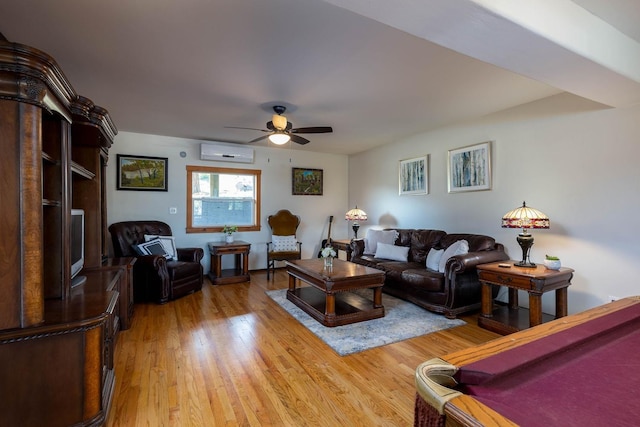 living room featuring a ceiling fan, light wood-style flooring, and a wall mounted AC