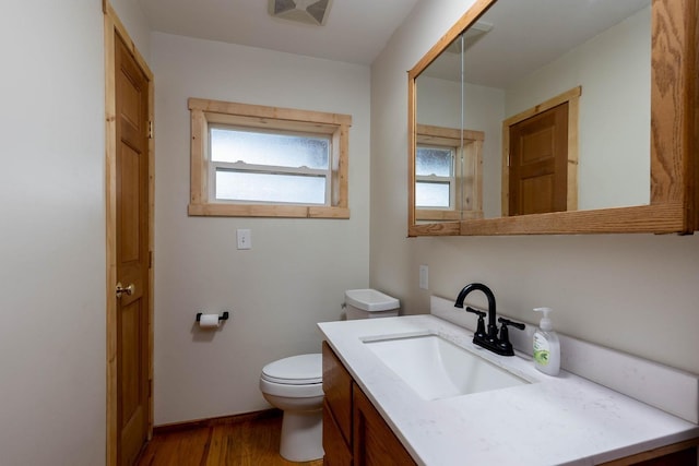 bathroom featuring visible vents, wood finished floors, vanity, and toilet