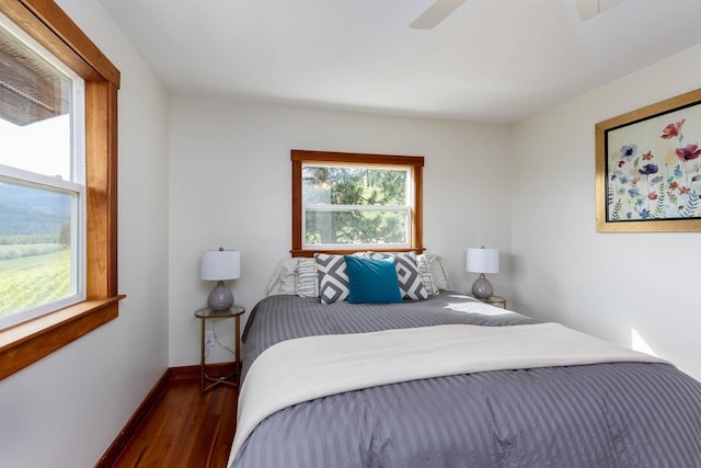 bedroom featuring ceiling fan, baseboards, and wood finished floors