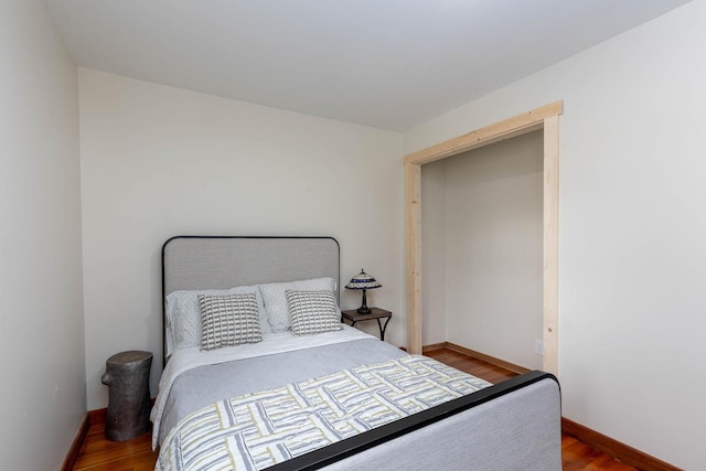 bedroom with wood finished floors and baseboards