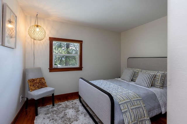 bedroom with baseboards and wood finished floors