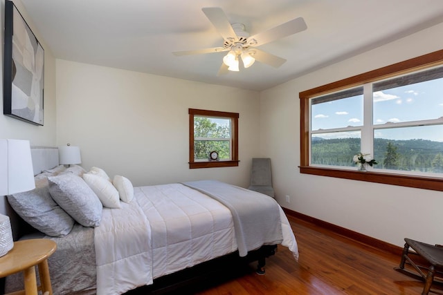 bedroom featuring ceiling fan, wood finished floors, and baseboards