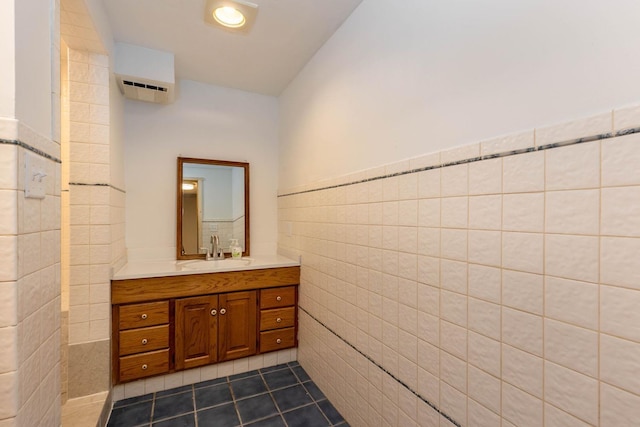 bathroom featuring a wainscoted wall, vanity, tile walls, a wall mounted AC, and tile patterned floors