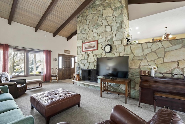 carpeted living room with wood ceiling, beamed ceiling, a stone fireplace, high vaulted ceiling, and a notable chandelier