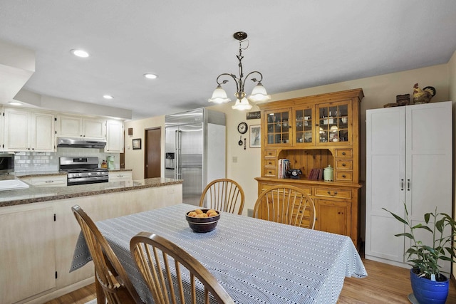 dining area featuring light wood-style floors, an inviting chandelier, and recessed lighting