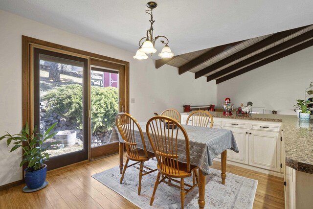 dining area featuring a chandelier, light wood-type flooring, and vaulted ceiling with beams