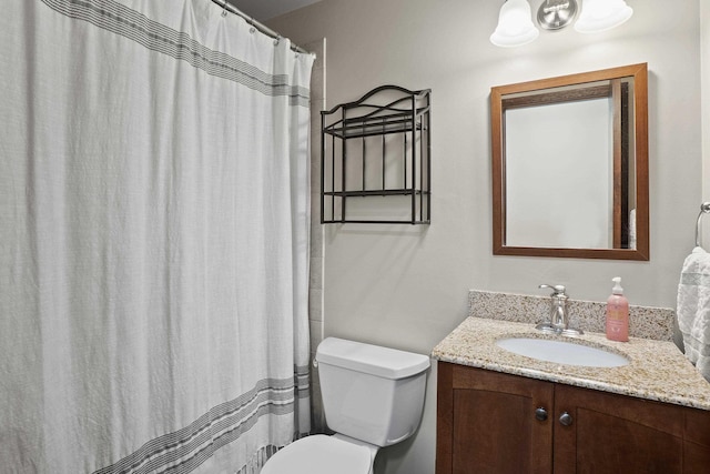 bathroom featuring a shower with shower curtain, vanity, and toilet