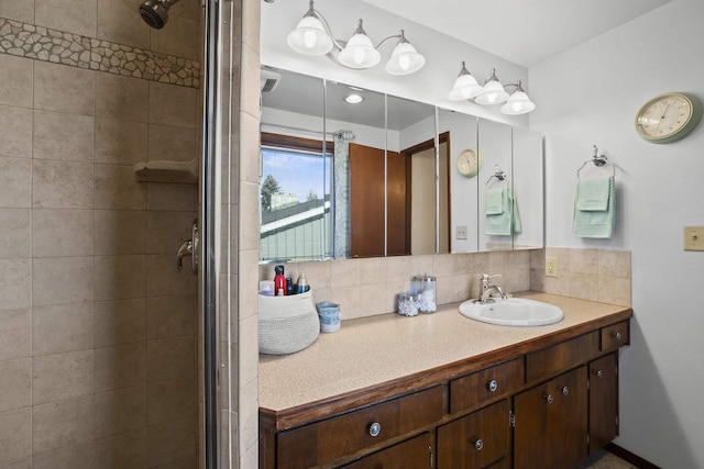 full bath with tasteful backsplash, a stall shower, and vanity